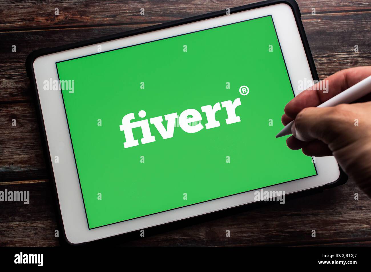 Kumamoto, JAPAN - Mai 13 2021 : Logo von Fiverr, einem israelischen Online-Marktplatz für freiberufliche Dienste, auf Tablet. Hand mit kabellosem Stylus-Stift. Stockfoto
