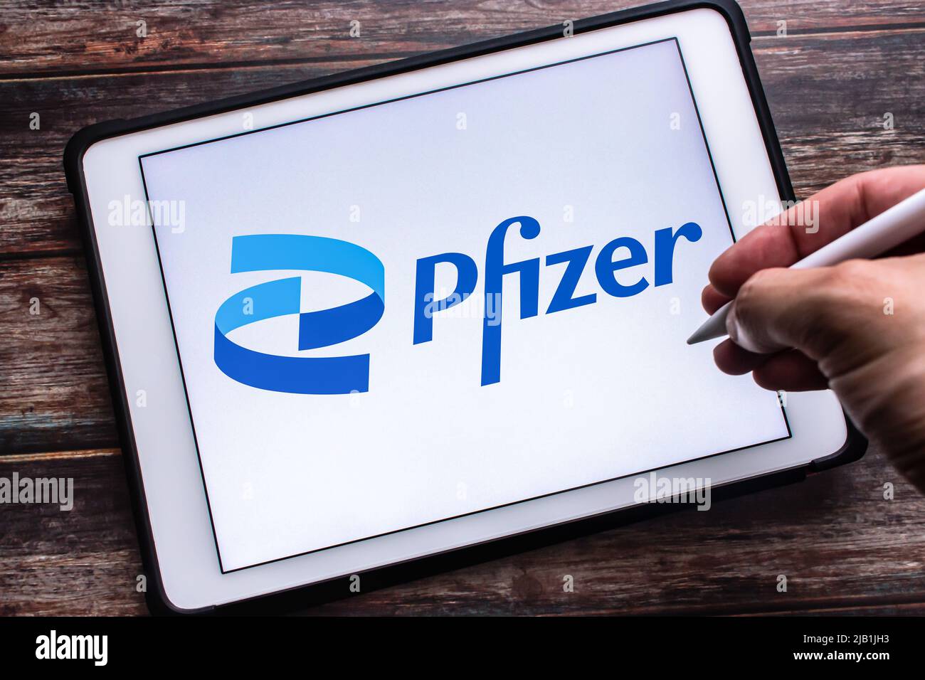 Kumamoto, JAPAN - Jul 27 2021 : Logo des US-Pharma- und Biotechnologiekonzerns Pfizer Inc. Auf Tablet. Mann Hand hält drahtlosen Stift. Stockfoto