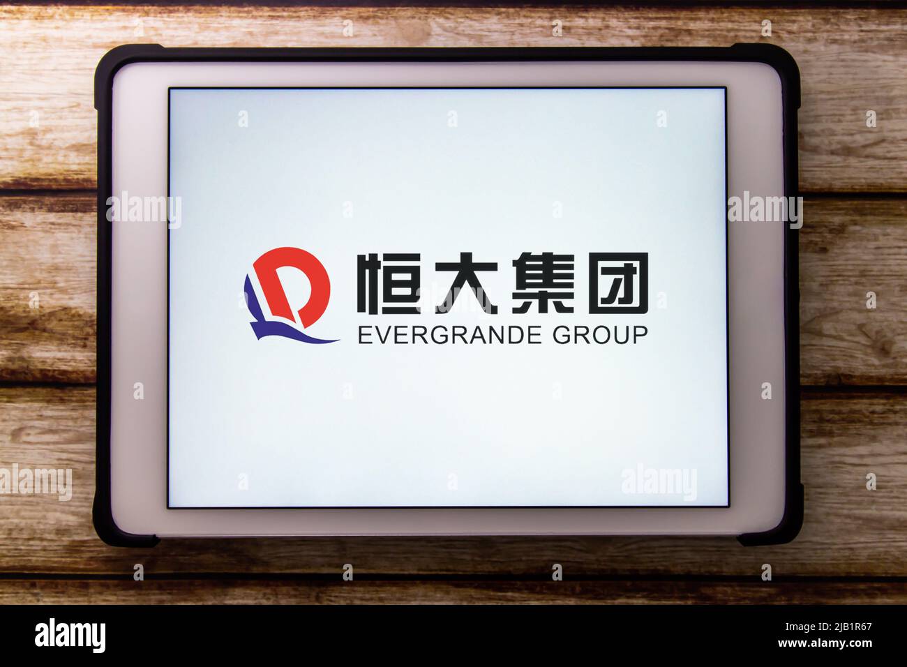 Kumamoto, JAPAN - Sep 22 2021 : Chinas 2. größter Immobilienentwickler Evergrande (The Evergrande Real Estate Group) auf einem Tablet auf einem schäbigen Holztisch Stockfoto