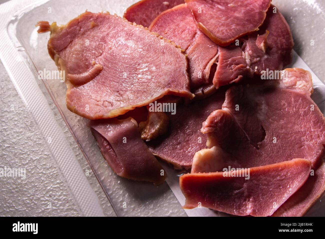 Die Scheiben geräucherter Rinderzungen in der Packung in der Plastikverpackung, die von einem lokalen Supermarkt in Japan auf dem Tisch verkauft wird. Stockfoto