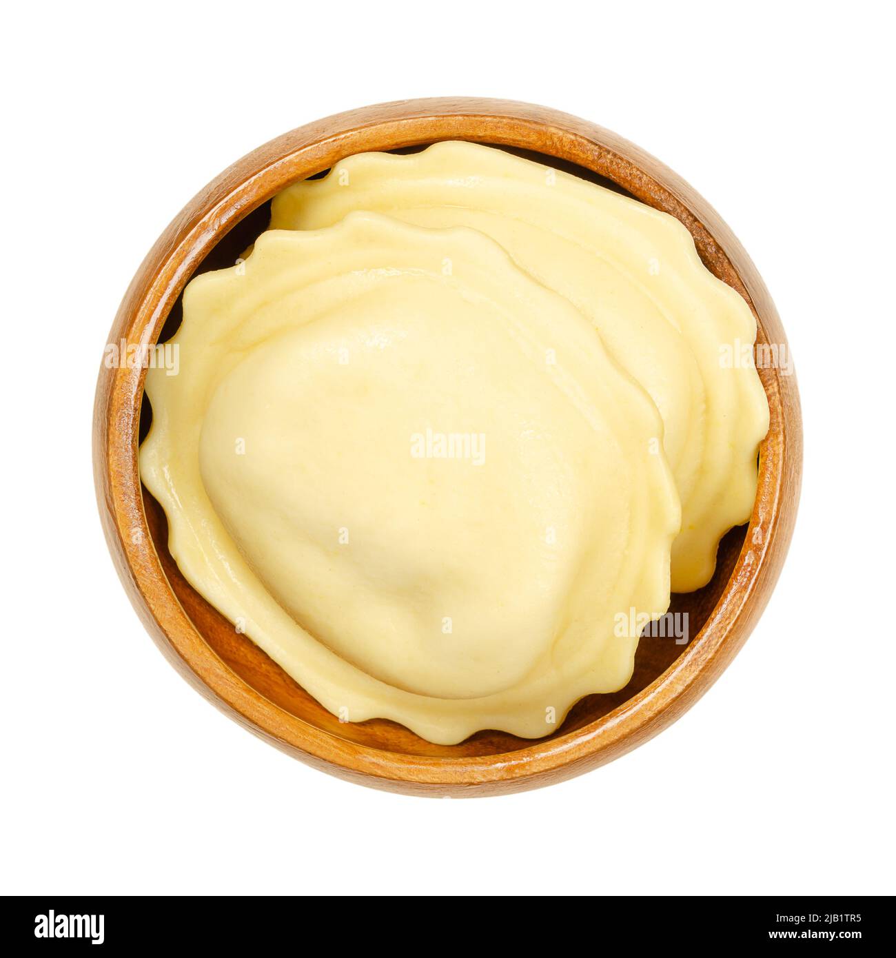 Große gefüllte Knödel in einer Holzschüssel. Ungekochte, gefüllte Eiernudeln, Füllung in dünnen Teig gewickelt, fertig zum Kochen, Dampfgaren oder Braten. Stockfoto