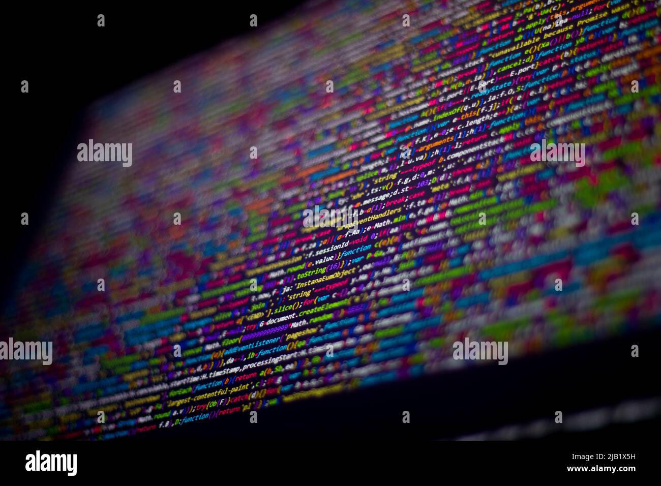 Farbenfroher Code-Hintergrund. Komprimierter javascript-Code auf dem Computerbildschirm. Bildschirm für die Codierung von Softwareentwicklern Stockfoto
