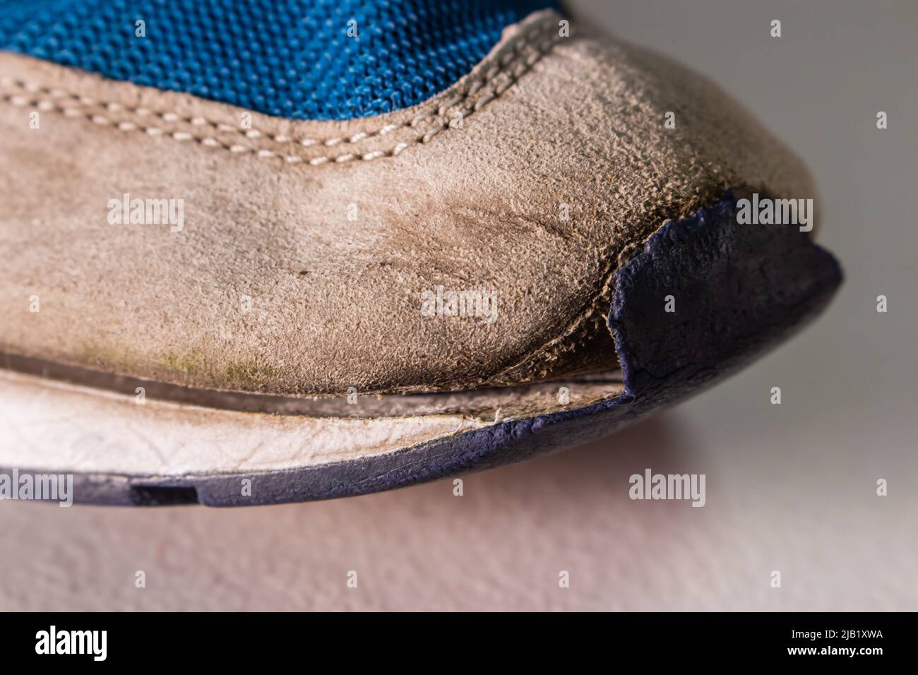 Alte zerbrochene Schuhe aus der Nähe. Der Zehenteil des Schuhs hat Risse. Die Schuhe sind verwittert und stark abgenutzt. Stockfoto