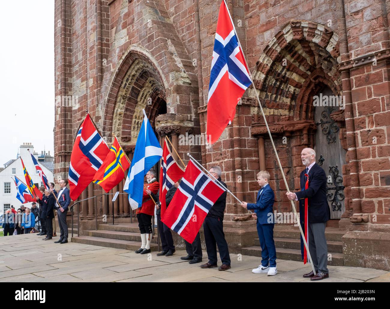 Fahnenträger halten die Flaggen Norwegens und Schottlands vor der St. Magnus Cathedral hoch, um den Norway Day im Stadtzentrum von Kirkwall, Orkney Islands, SCO, zu feiern. Stockfoto