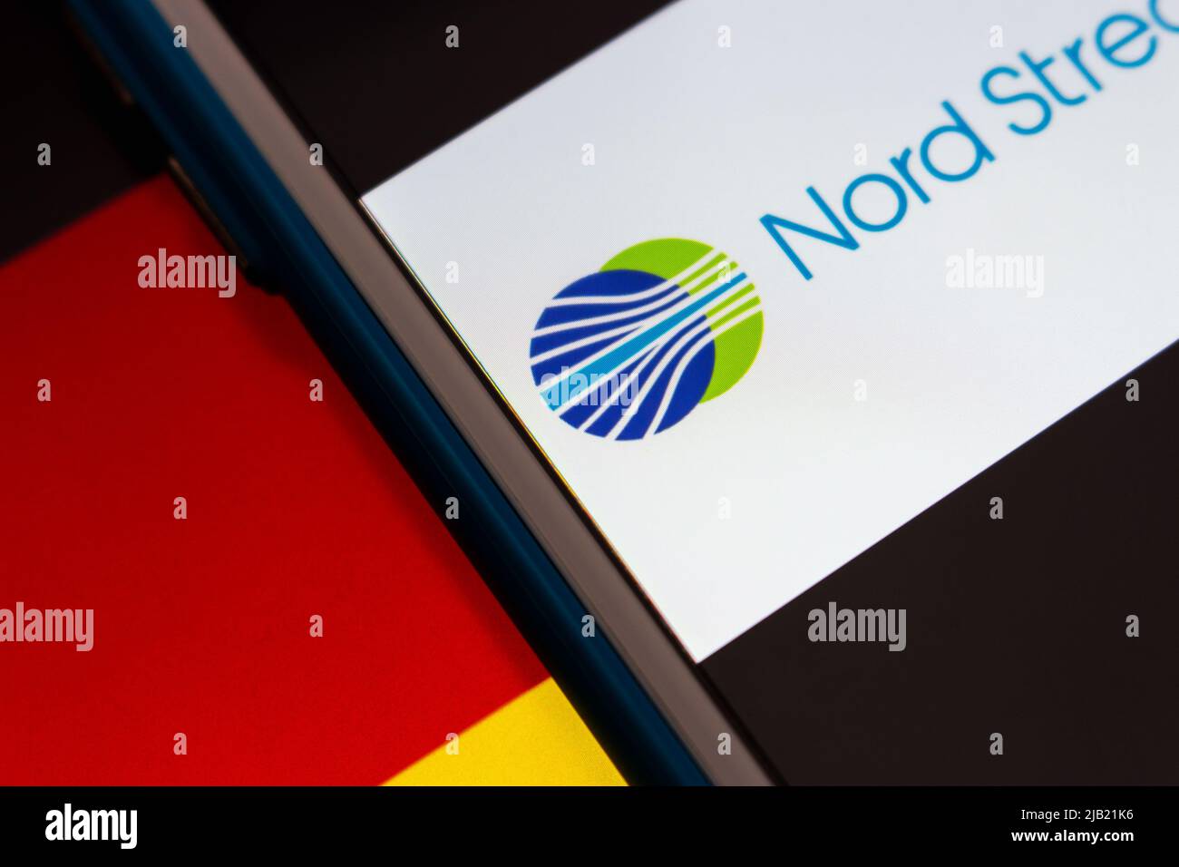 Nord Stream 2 Logo auf iPhone auf deutscher Flagge. Nord Stream ist ein Offshore-Erdgasleitungsnetz, das unter der Ostsee von Russland nach Deutschland läuft Stockfoto