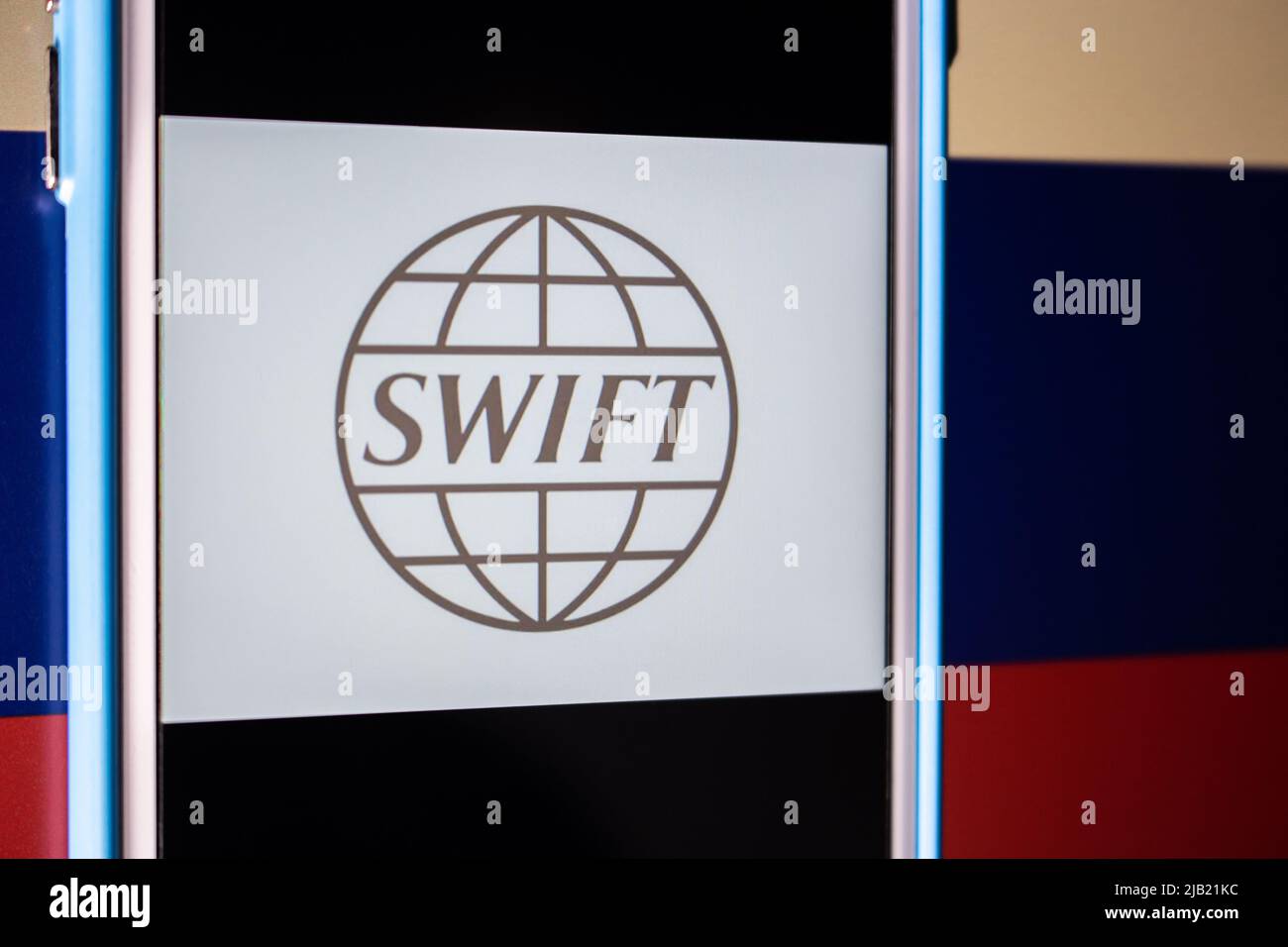 Logo von SWIFT (The Society for Worldwide Interbank Financial Telecommunication) auf dem iPhone auf russischer Flagge. Sanktionen für Ukraine Invasion Konzept Stockfoto