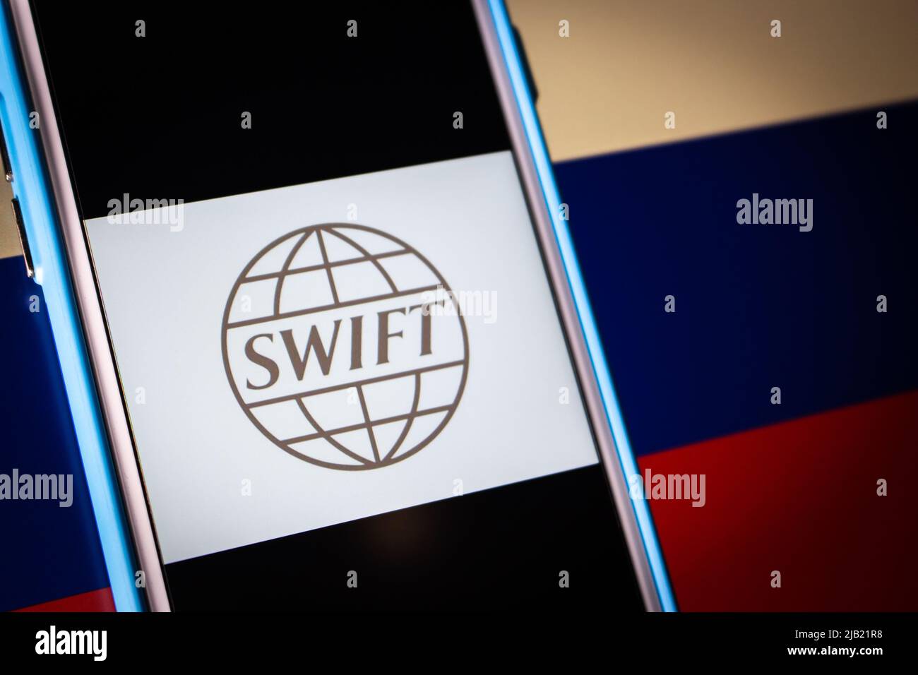 Logo von SWIFT (The Society for Worldwide Interbank Financial Telecommunication) auf dem iPhone auf russischer Flagge in dunkler Stimmung. Konzept der Kriegssanktion in der Ukraine Stockfoto