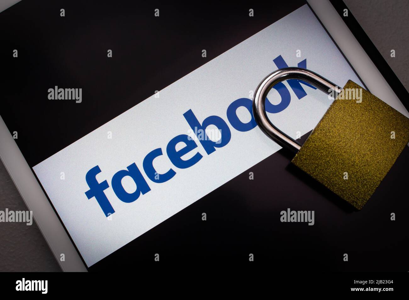 Kumamoto, JAPAN - Feb 22 2022 : Facebook-Logo mit großem Vorhängeschloss auf dem Tablet in dunkler Stimmung. Digitale Sicherheit im Social-Media-Account-Konzept. Stockfoto