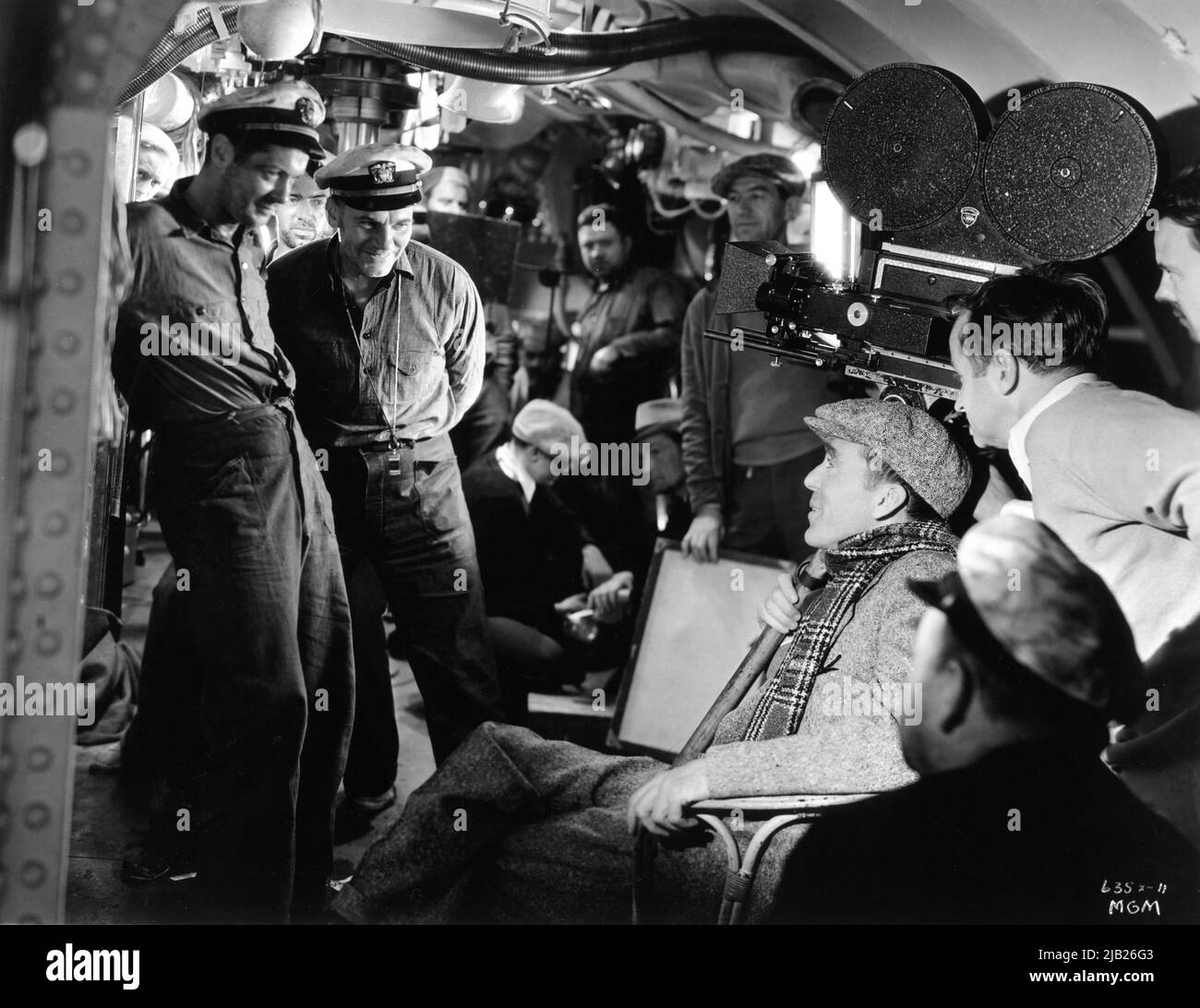 ROBERT MONTGOMERY WALTER HUSTON mit Regisseur JACK CONWAY und dem Kameramann HAL / HAROLD ROSSON am Set offen während der Dreharbeiten auf dem U-Boot-Set der HÖLLE UNTER 1933 Regisseur JACK CONWAY aus dem Buch Pigboats von Commander Edward Ellsberg Art Direction Cedric Gibbons Metro Goldwyn Mayer Stockfoto