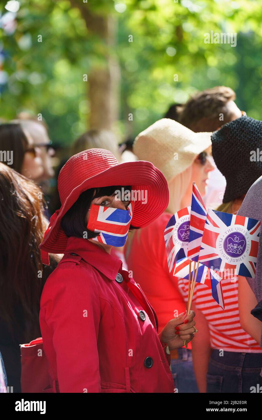 LONDON - 2. JUNI: Eine Dame in einer Union Jack Gesichtsmaske schaut sich die Trooping the Color Zeremonie am 2. Juni 2022 im Zentrum von London an. Kredit: David Levenson/Alamy Live Nachrichten Stockfoto