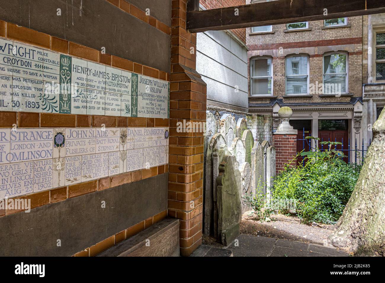 Grabsteine und Keramik-Gedenktafeln oder -Fliesen, die die Wände des Watts Memorial to Heroic Self-Sacrifice im Postman’s Park London, EC1, säumen Stockfoto