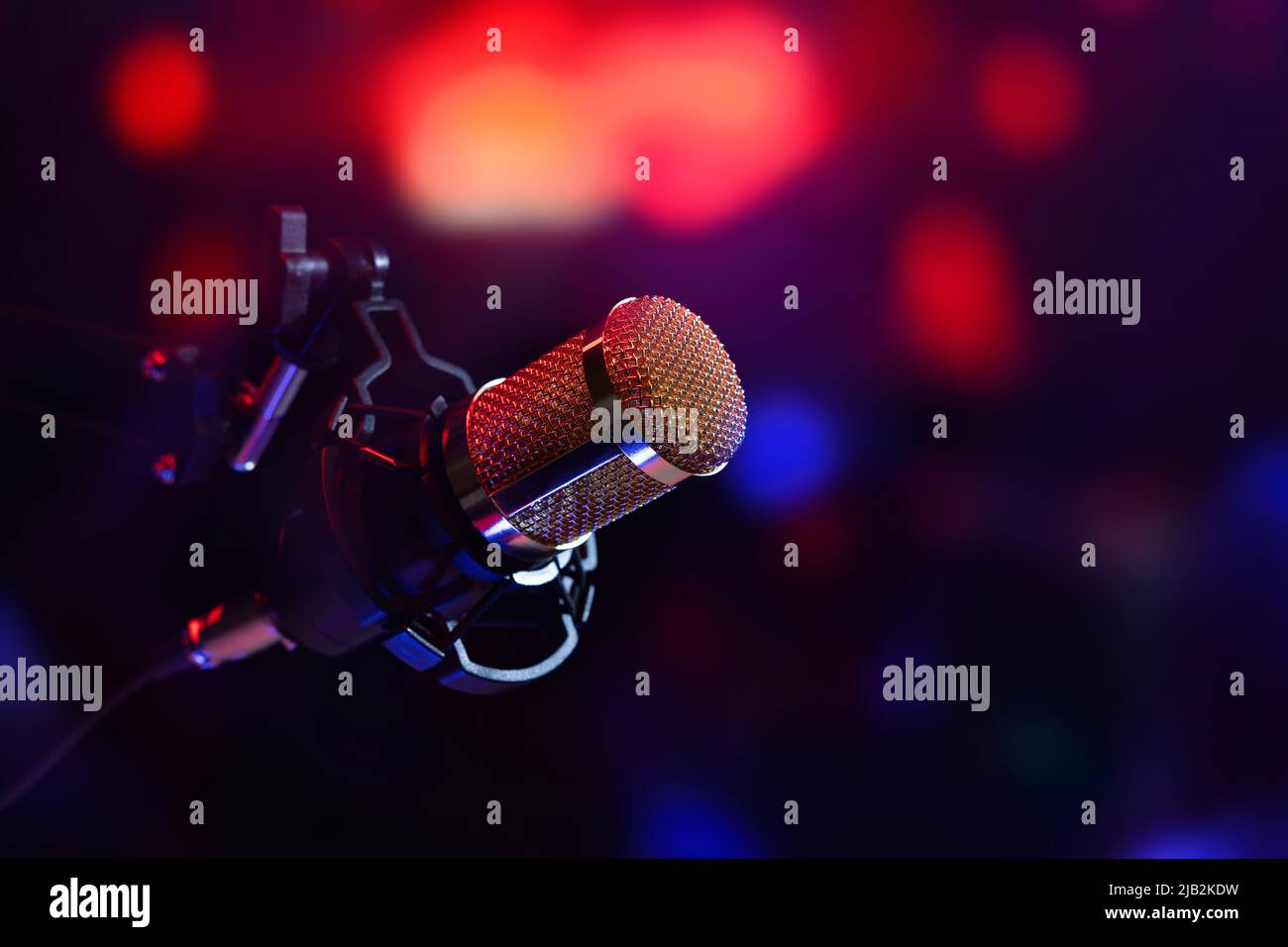 studiomikrofon in Neonlicht. Tonaufnahmesequipment Stockfoto