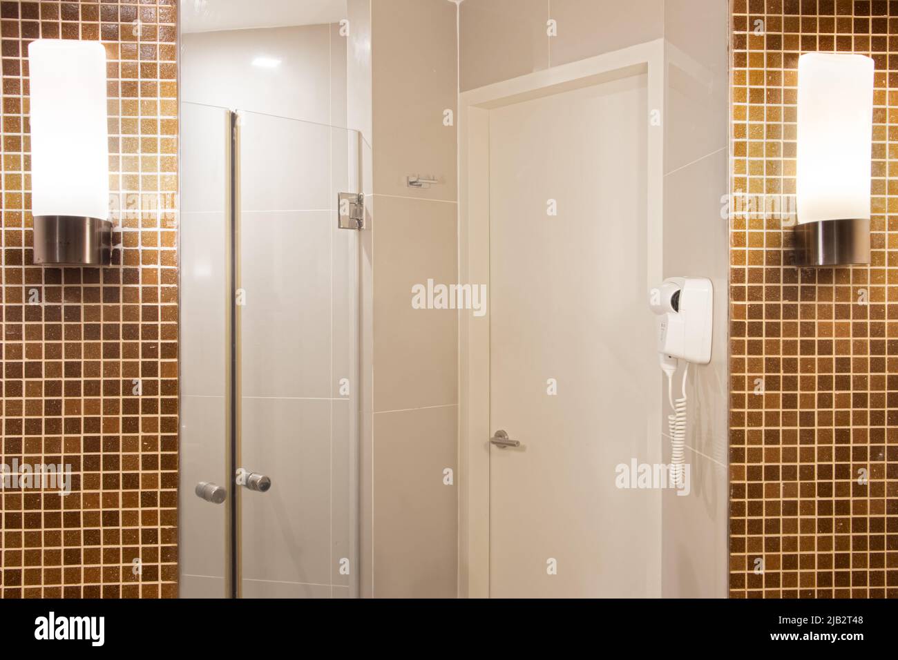 Spiegel an der Badezimmerwand mit Leuchten an den Seiten Stockfoto