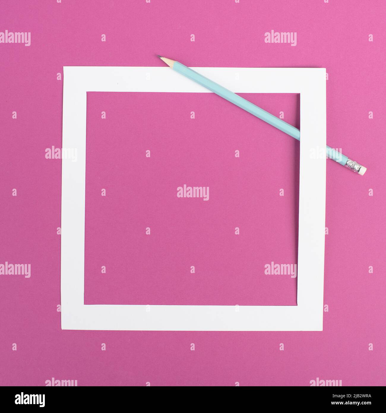 Bleistifte auf einem rosa Papierhintergrund, weißer Rahmen mit Platz für Text, Minimalismus, kreatives und geschäftliches Konzept, pastellfarben Stockfoto