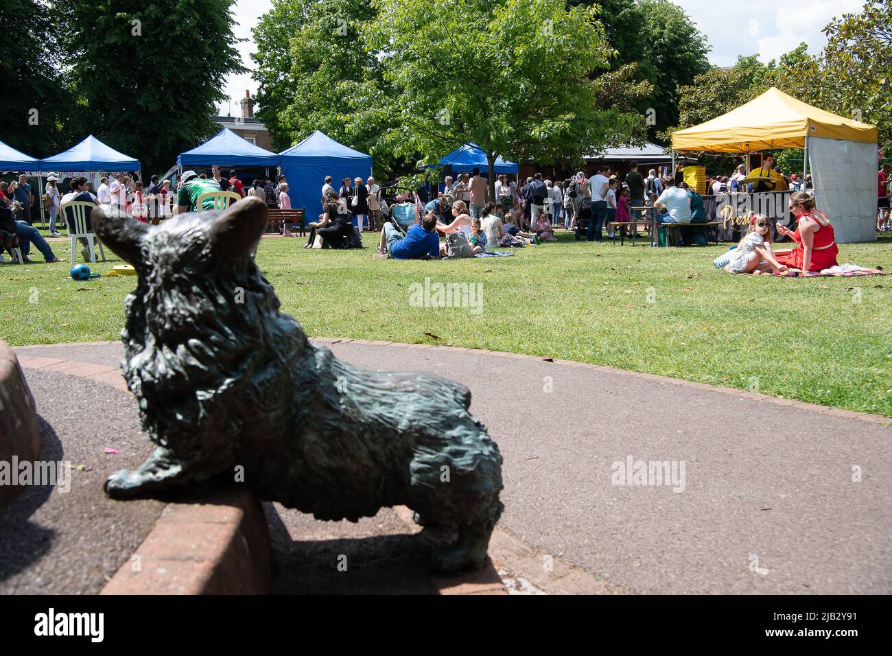 Windsor, Großbritannien. 2.. Juni 2022. Ein Bronze-Corgi beobachtet das Ereignis. Ein von Ihrer Majestät der Königin gestifteter Ochse wurde heute in Batchelor's Acre gebraten. Menschen, die eine Eintrittskarte für den Ochsenbraten gekauft haben, erhielten ebenfalls eine Teilnahmebescheinigung. Die ersten Scheiben wurden von Sir James Perowne, Govenor von Windsor Castle, und dem Bürgermeister von Windsor und Maidenhead, Cllr Christine Bateson, geschnitten. Quelle: Maureen McLean/Alamy Live News Stockfoto
