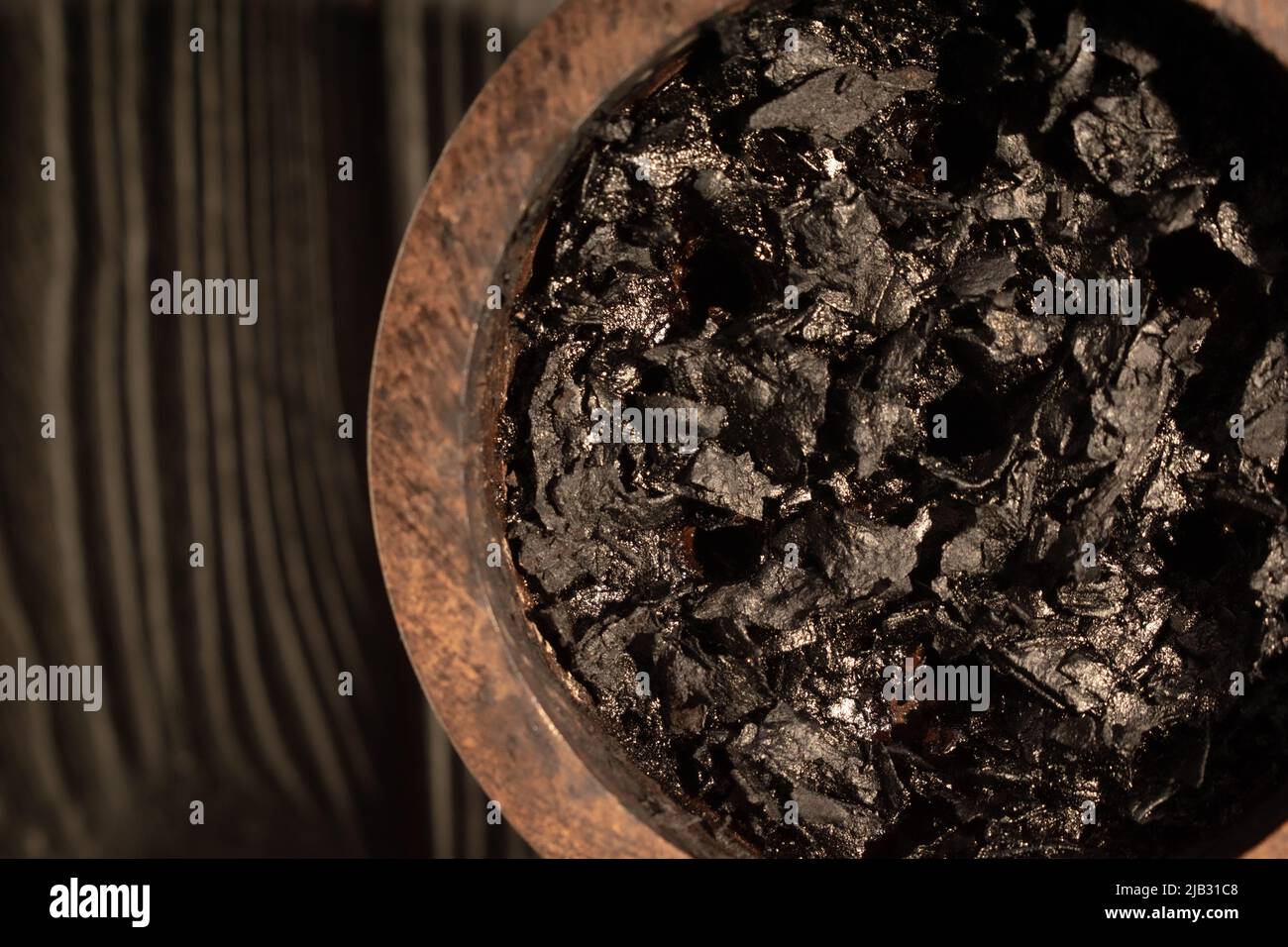 Shisha-Schale mit verbranntem Tabak und Holzkohle zum Rauchen auf dunklem Hintergrund. Ort für Ihren Text. Stockfoto