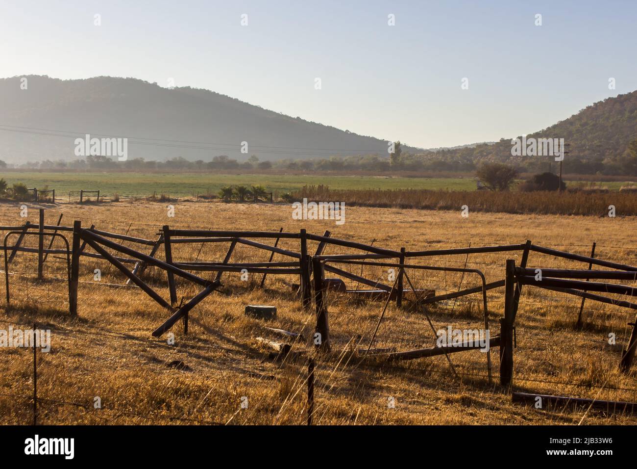 Blick am frühen Morgen auf eine Farm im Rural Free State, Südafrika, mit einem gebrochenen Zaun im Vordergrund Stockfoto