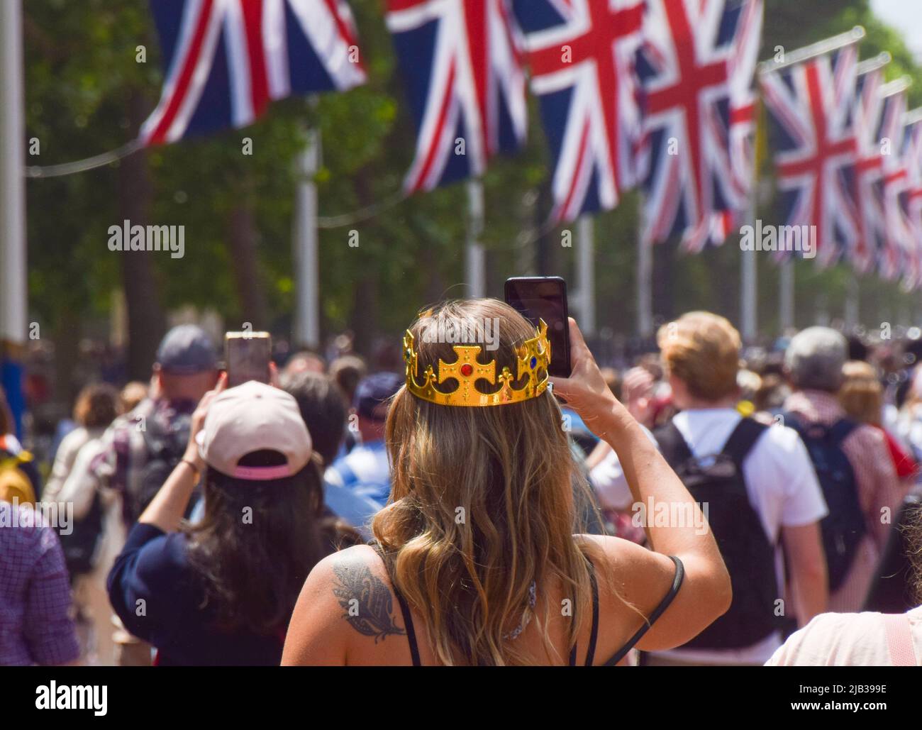 London, England, Großbritannien. 2.. Juni 2022. Eine Frau mit einer Plastikkrone fotografiert in der Mall. Zehntausende Menschen versammelten sich im Zentrum Londons, um das Platin-Jubiläum der Königin am ersten Tag eines besonderen, erweiterten viertägigen Wochenendes anlässlich des 70.. Jahrestages der Thronbesteigung der Königin zu feiern. (Bild: © Vuk Valcic/ZUMA Press Wire) Stockfoto