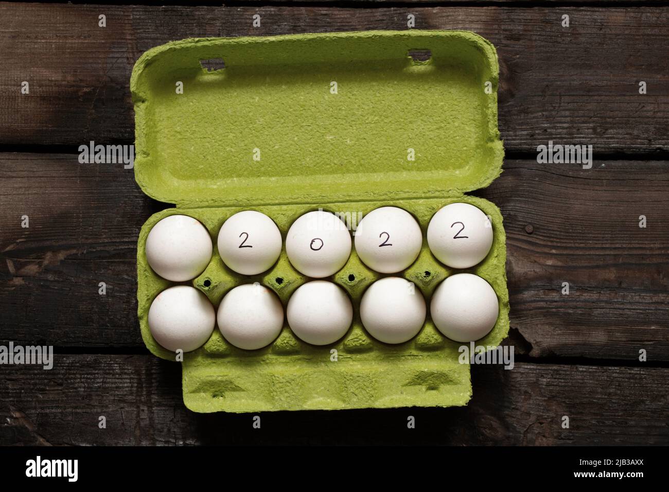 Hühnereier in Schachteln und Text 2022 über Eier, glückliches neues Jahr 2022, Hühnereier auf dem Tisch Stockfoto