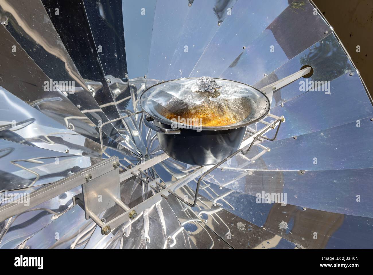 Kochen mit Sonnenenergie, parabolischer Solarofen in der Mitte des Kochens ein Gericht dank Sonnenenergie Stockfoto