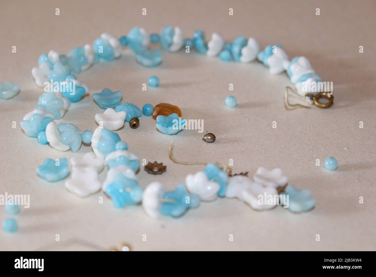 Verstreute Perlen auf dem Tisch, zerrissener Schmuck zur Reparatur Stockfoto