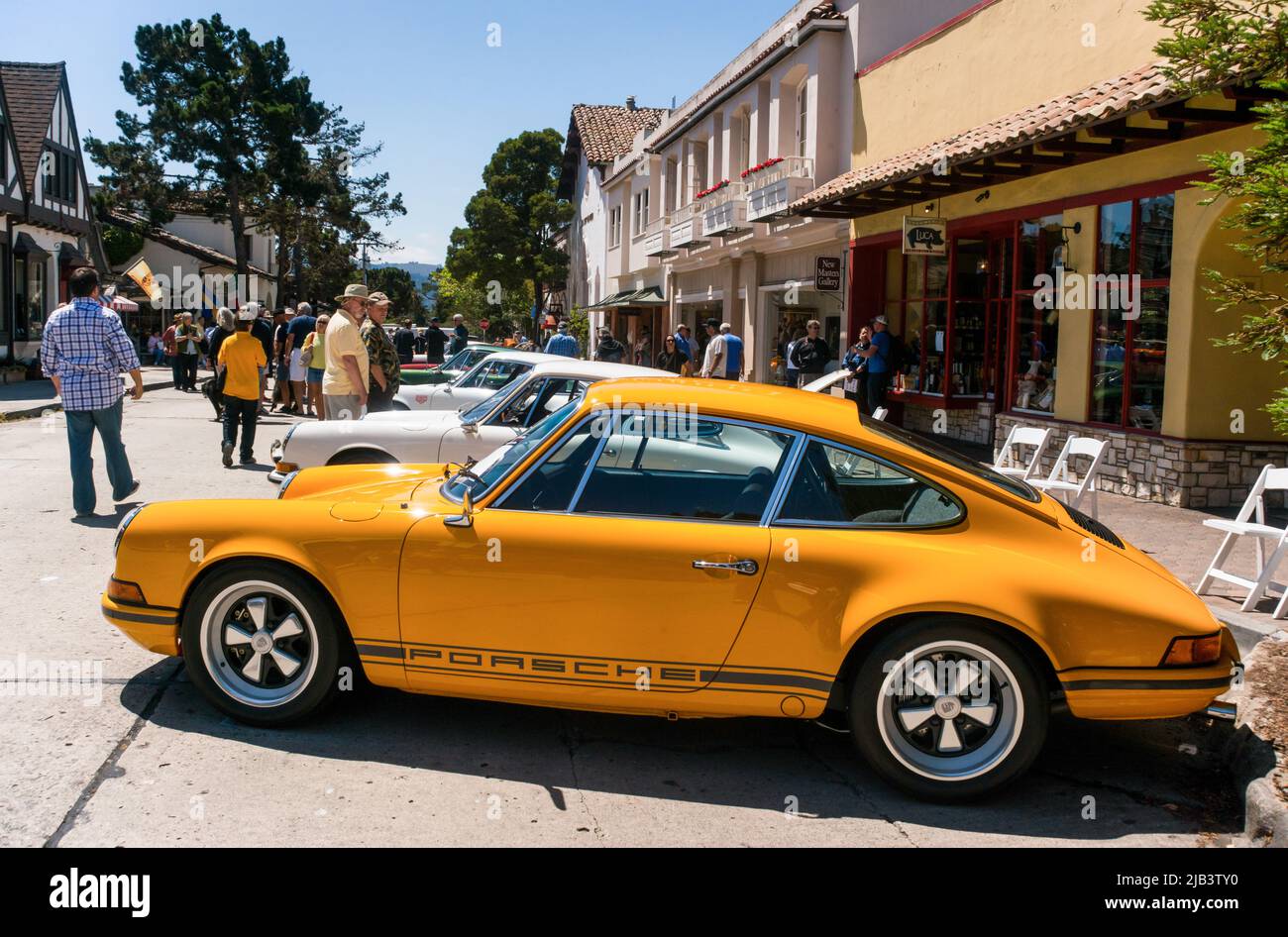 Die Zuschauer genießen Oldtimer in der Innenstadt von Carmel, die während der Monterey Car Week auf dem Carmel-by-the-Sea Concours auf der Avenue gesehen werden Stockfoto