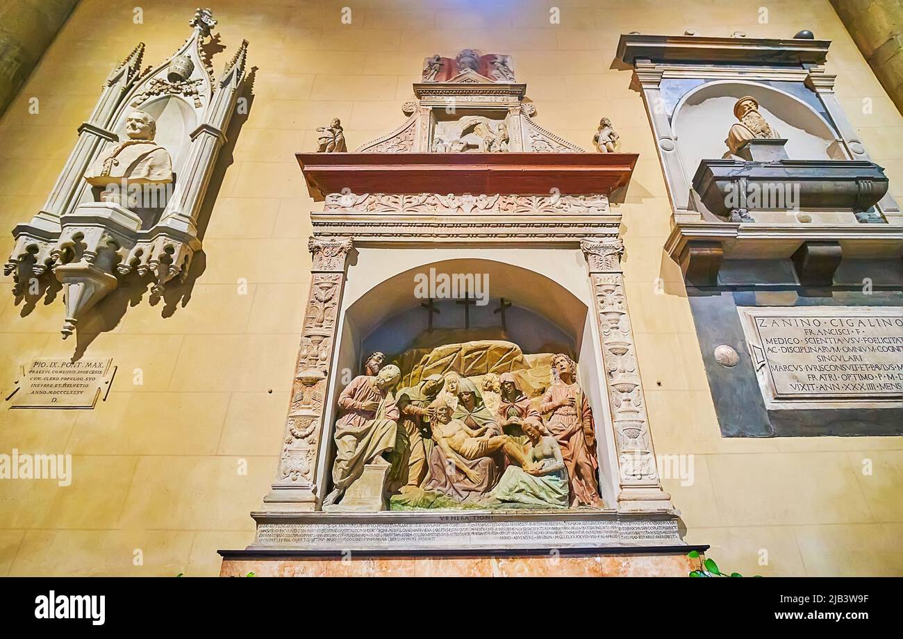 COMO, ITALIEN - 20. MÄRZ 2022: Die Kapelle der Santa Maria Assunta Kathedrale mit skulpturalen Dekorationen an der Wand und Pieta skulpturale Gruppe in Nische, auf Stockfoto