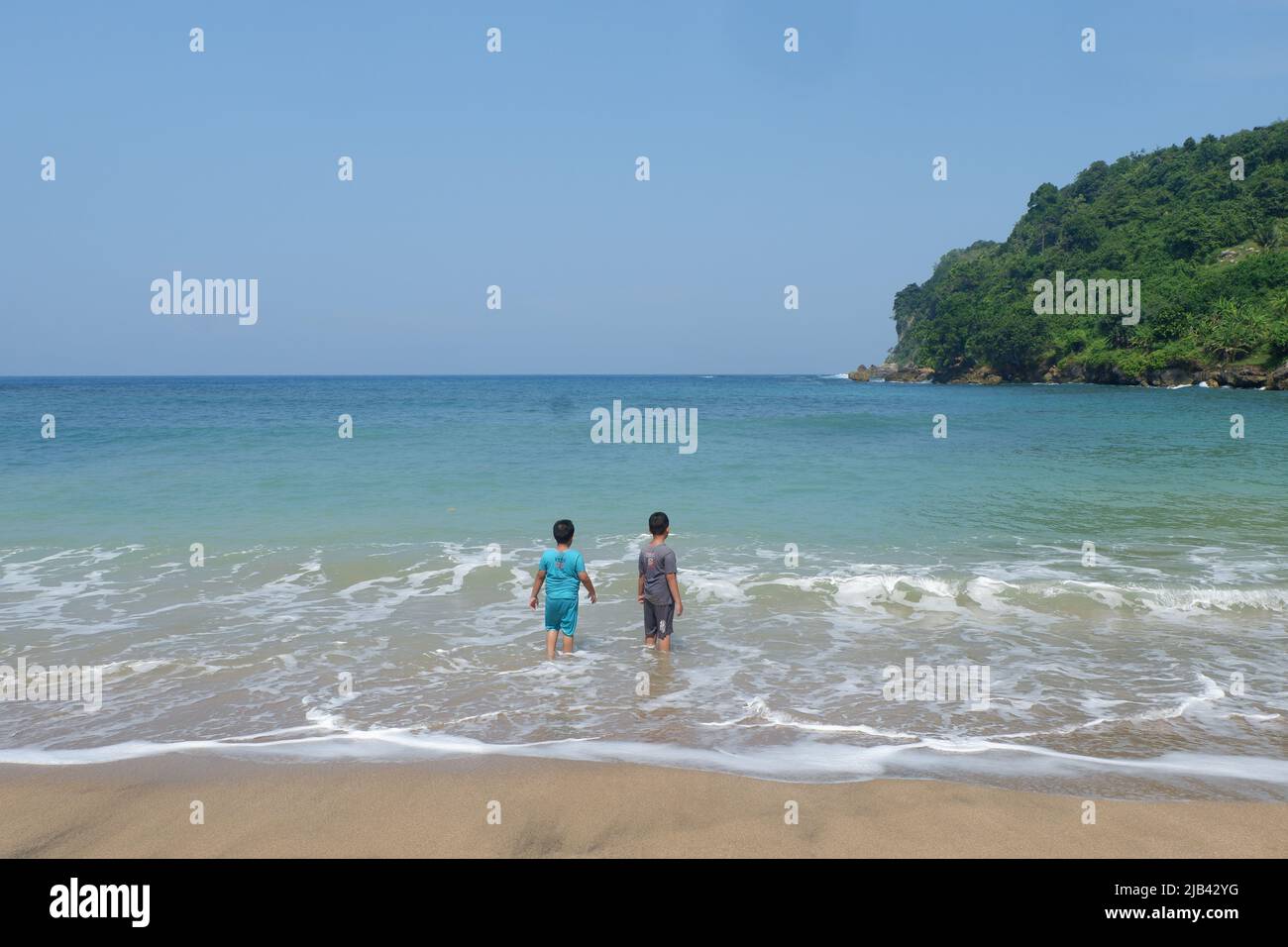 Den Charme von Pangi Beach mit Ihrem besten Freund zu genießen, ist eine lohnende Erfahrung, ruhige Wellen, blaue Strandfarben, eine epische Kombination. Stockfoto