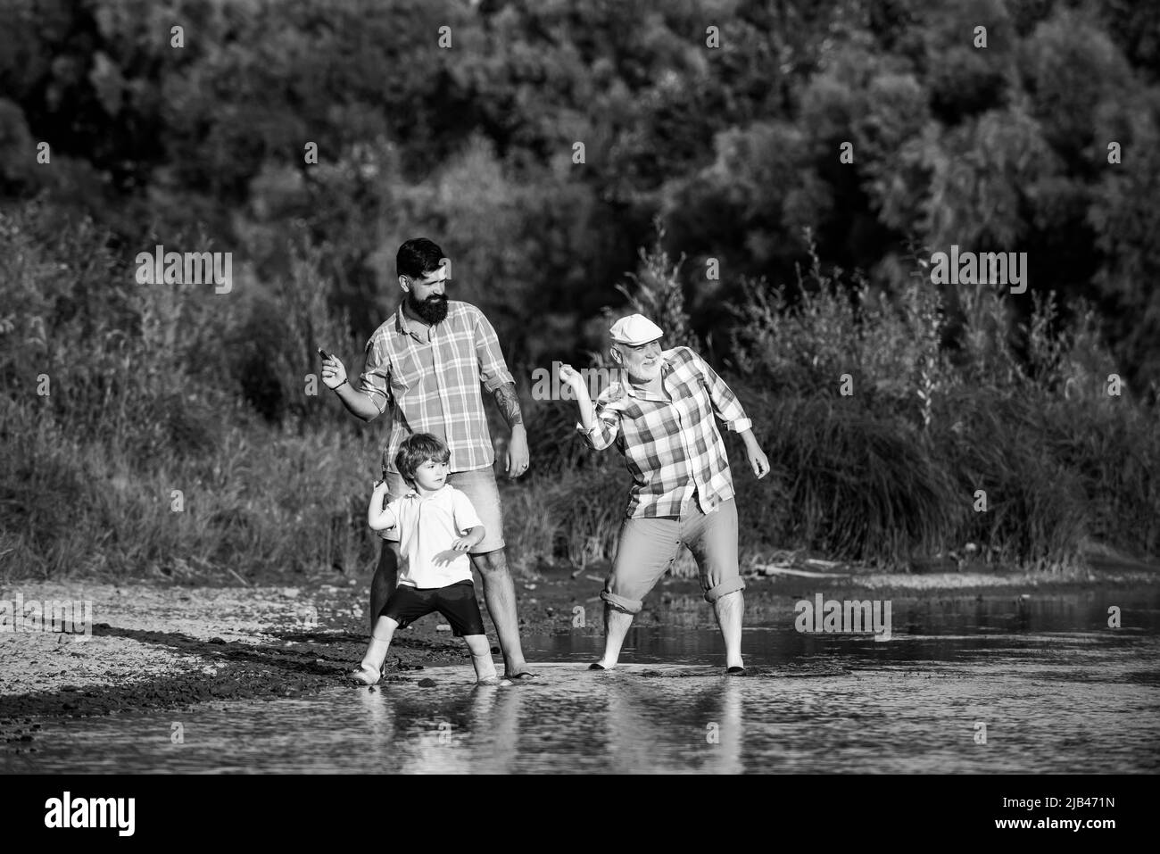 Familienspiel des Steinspringens. Familie in drei Generationen. Vater, Sohn und Großvater entspannen sich zusammen. Stockfoto