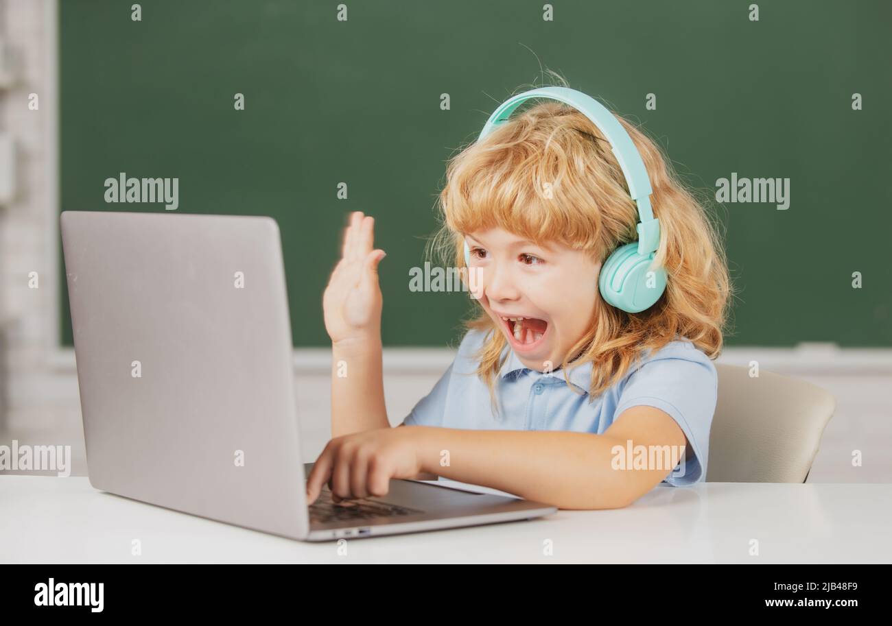 Aufgeregt Schuljunge, erstaunt Schüler trägt Kopfhörer schreiben auf Laptop, hören Audio-Unterricht am Computer. Videocall, E-Studie mit Tutor entfernt. Stockfoto