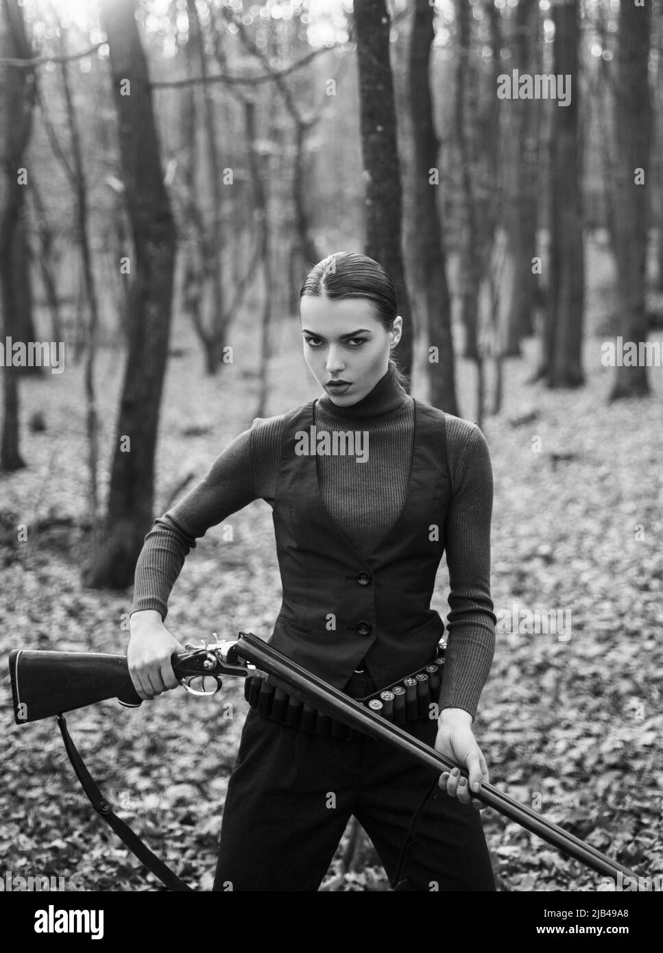 Frau mit Waffe. Zielschuss. Erfolgreiche Jagd. Jagdsport. Militärische Mode. Erfolge von Zielen. Mädchen mit Gewehr. Jagd jagen. Waffenladen Stockfoto