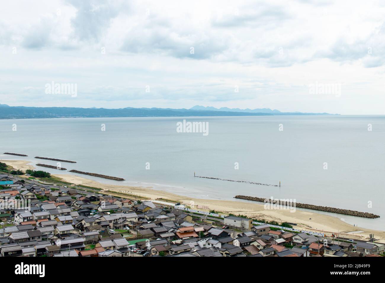 Landschaft von Izumo Stadt und Strand von der Hügelspitze am Mt. Hounouzan Park, Shimane in Japan, an bewölkten Tagen. In der Ferne befindet sich der Inasa-Strand (Bentenjima) Stockfoto