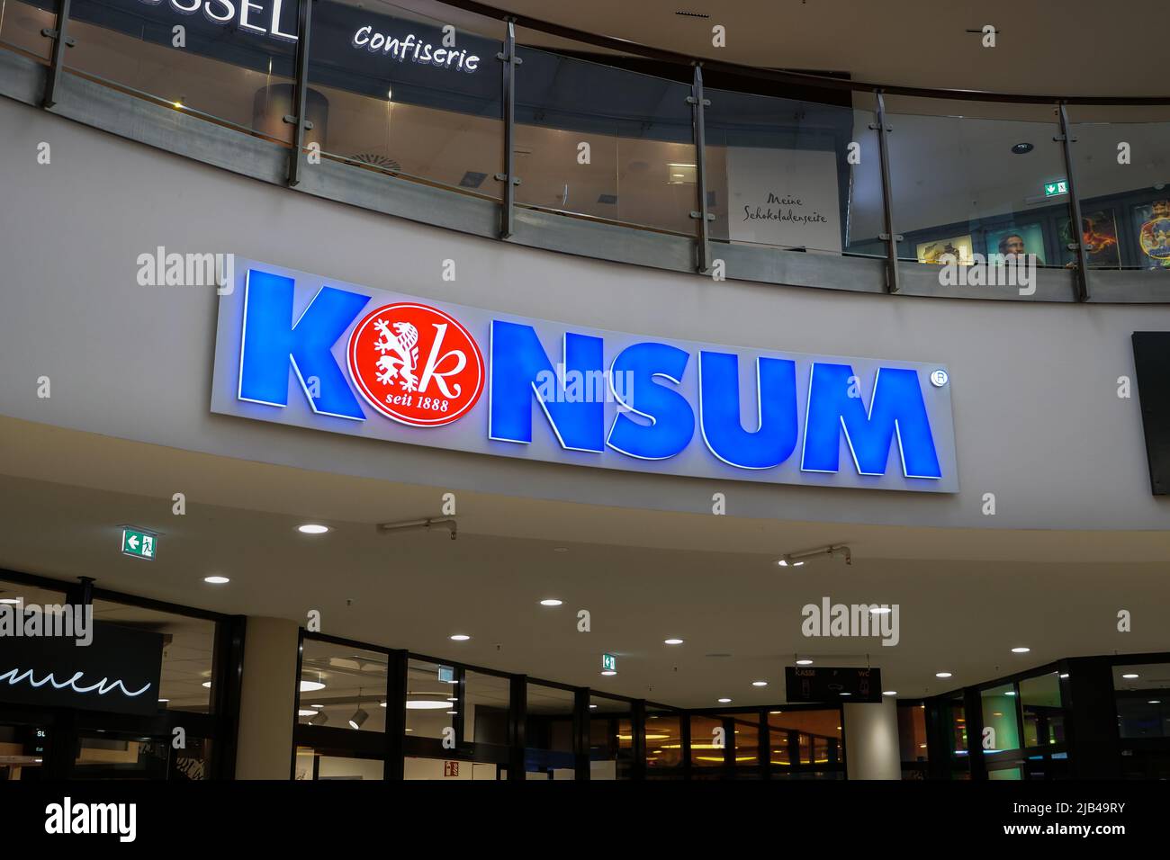 Konsum Dresden EG Supermarktlogo in einem Einkaufszentrum. Traditionelles deutsches Lebensmittelgeschäft. Beleuchtetes Schild an der Innenwand im Innenraum. Stockfoto