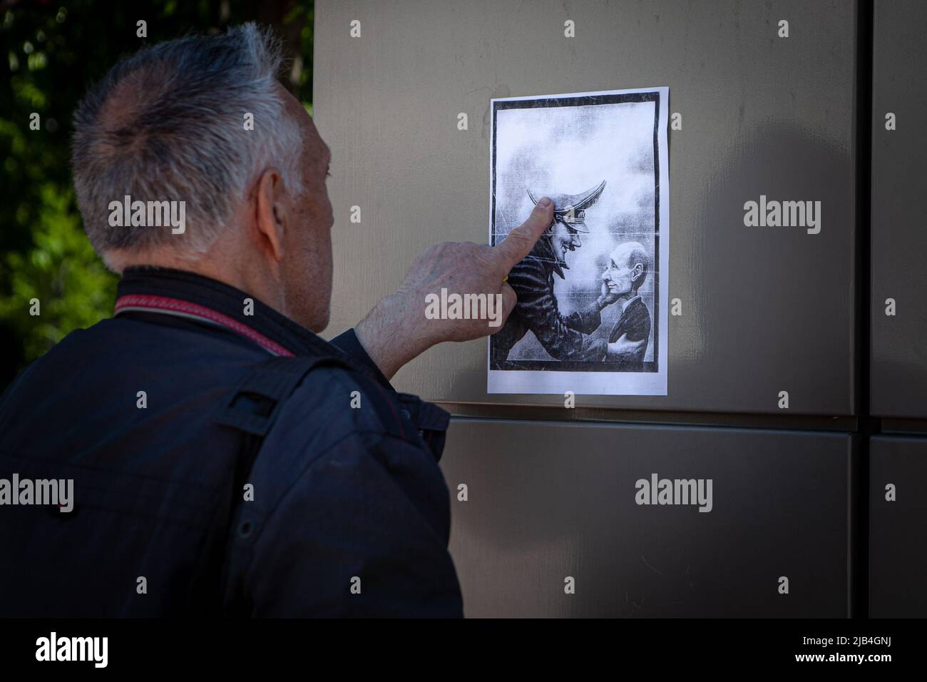 Kiew, Ukraine. 24.. Mai 2022. Ein Mann stellt Plakate auf, auf denen der russische Präsident Wladimir Putin als Adolf Hitler im Zentrum von Kiew dargestellt wird. Drei Monate nach der Schlacht von Kiew beginnt die Stadt wieder auf ein normales Niveau zu kommen, da Geschäfte und Restaurants geöffnet werden, nachdem sich die russischen Streitkräfte aus der Region zurückgezogen haben. (Bild: © Richard Wright/SOPA Images via ZUMA Press Wire) Stockfoto