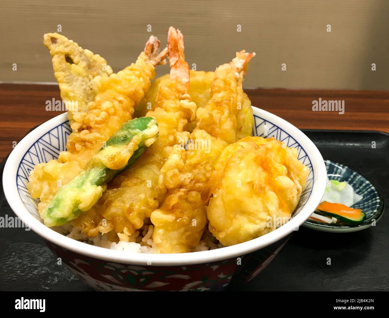 Sehne mit Gurken auf dem Teller im Restaurant. „Sehne“ ist eine Abkürzung für Tempura (frittierte Meeresfrüchte, Fleisch und Gemüse) und Donburi. Stockfoto