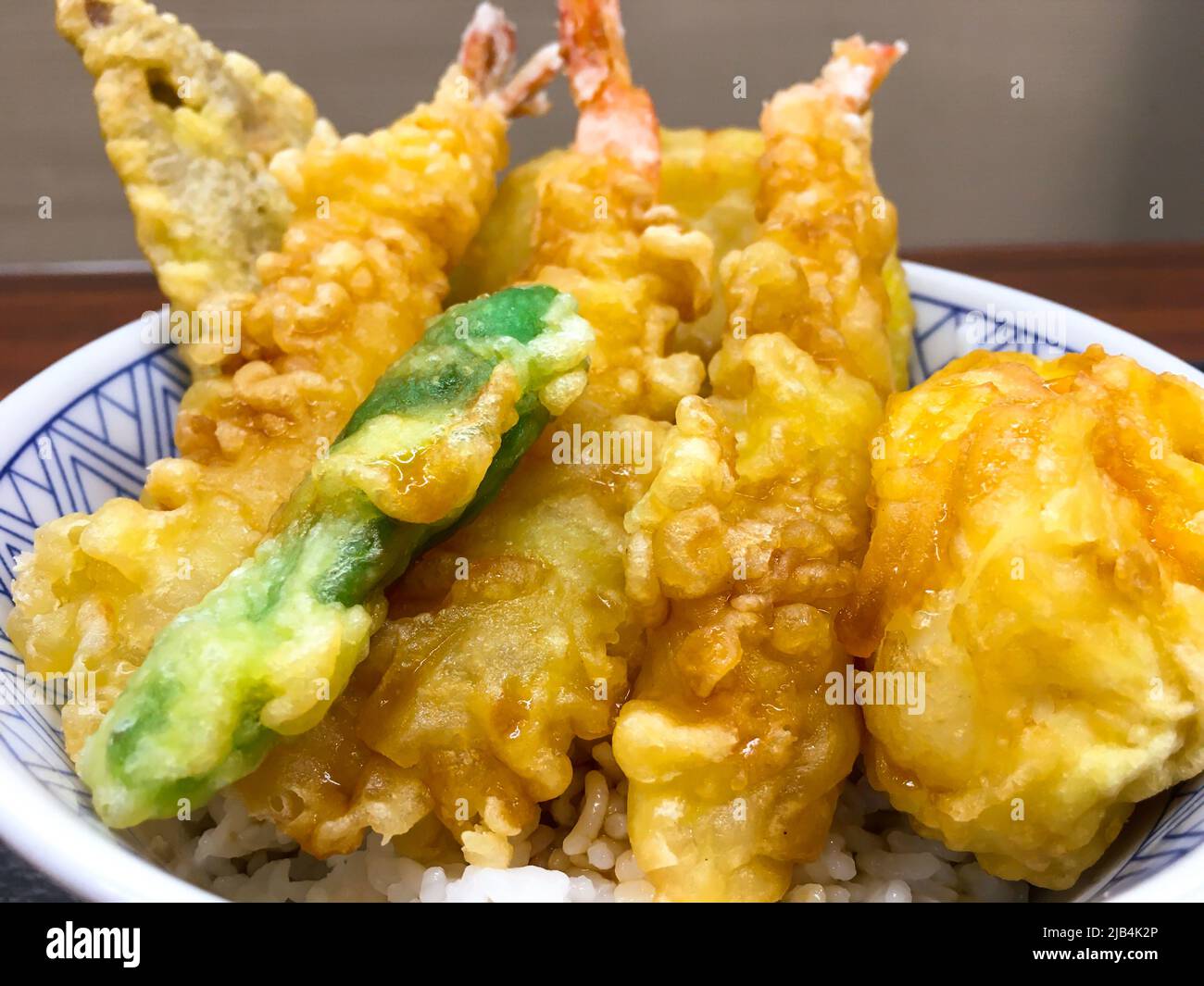 Nahaufnahme Tendon mit Gurken auf dem Teller im Restaurant. „Sehne“ ist eine Abkürzung für Tempura (frittierte Meeresfrüchte, Fleisch und Gemüse) und Donburi. Stockfoto