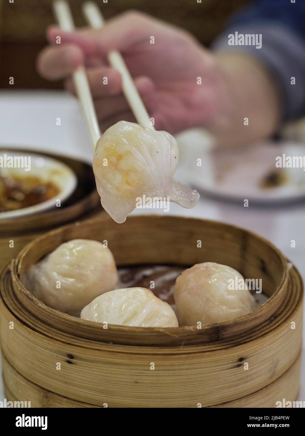 Köstliches chinesisches Dim Sum in einem chinesischen Restaurant, Essstäbchen mit gedämpfter Garnelenrolle Stockfoto