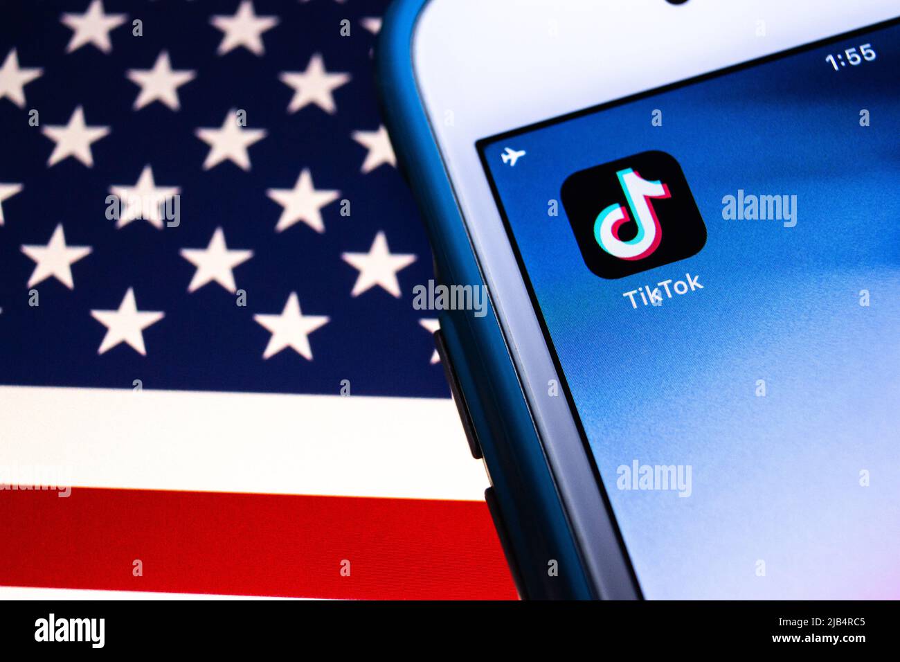 TikTok, ein chinesisches Video-Sharing SNS von Bytedance in Peking, auf dem iPhone unter US-Flagge. Präsident Trump unterzeichnet eine Exekutivordnung, die TikTok im Wesentlichen verbietet Stockfoto