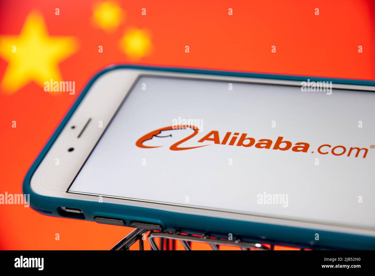 Alibaba.com Logo auf iPhone im Warenkorb mit chinesischer Flagge. Die Alibaba Group ist der weltweit größte Einzelhändler und E-Commerce-Anbieter. Stockfoto