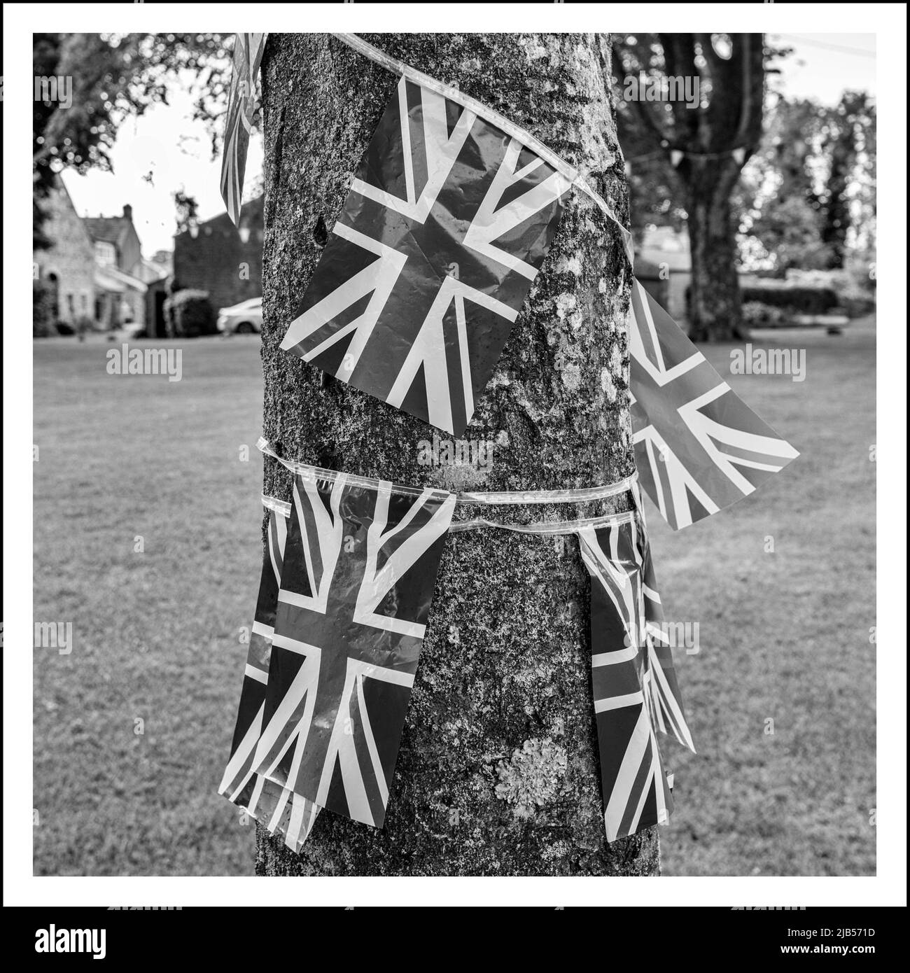 Village Green Long Preston, North Yorkshire, mit an Bäumen befestigten Union-Jacks auf dem Dorfgrün, anlässlich des Platin-Jubiläums der Königin Stockfoto