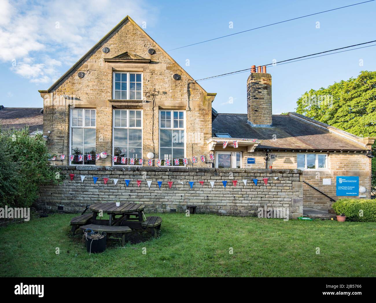 Flaggen und Fahnen auf dem Gesicht der Long Preston Stiftungsschule, School Lan, Long Preston, North Yorkshire zur Feier des Platin-Jubiläums der Königin. Stockfoto