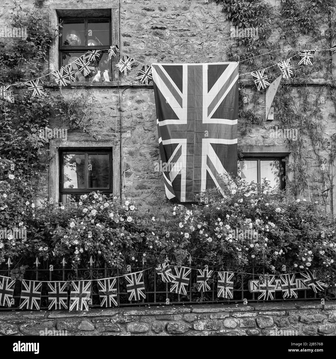 Flaggen und Verhängungen in Church St, Long Preston, North Yorkshire zur Feier des Platin-Jubiläums der Königin (Juni 2022). Stockfoto
