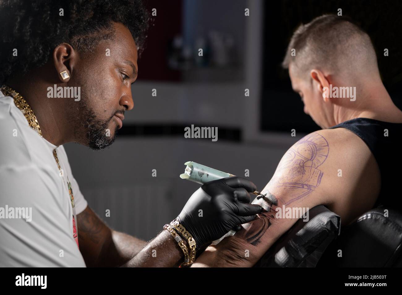 Filmische Aufnahme eines Tattoo-Künstlers, der im Tattoo-Studio Körperkunst kreiert. Hochwertige Fotografie. Stockfoto