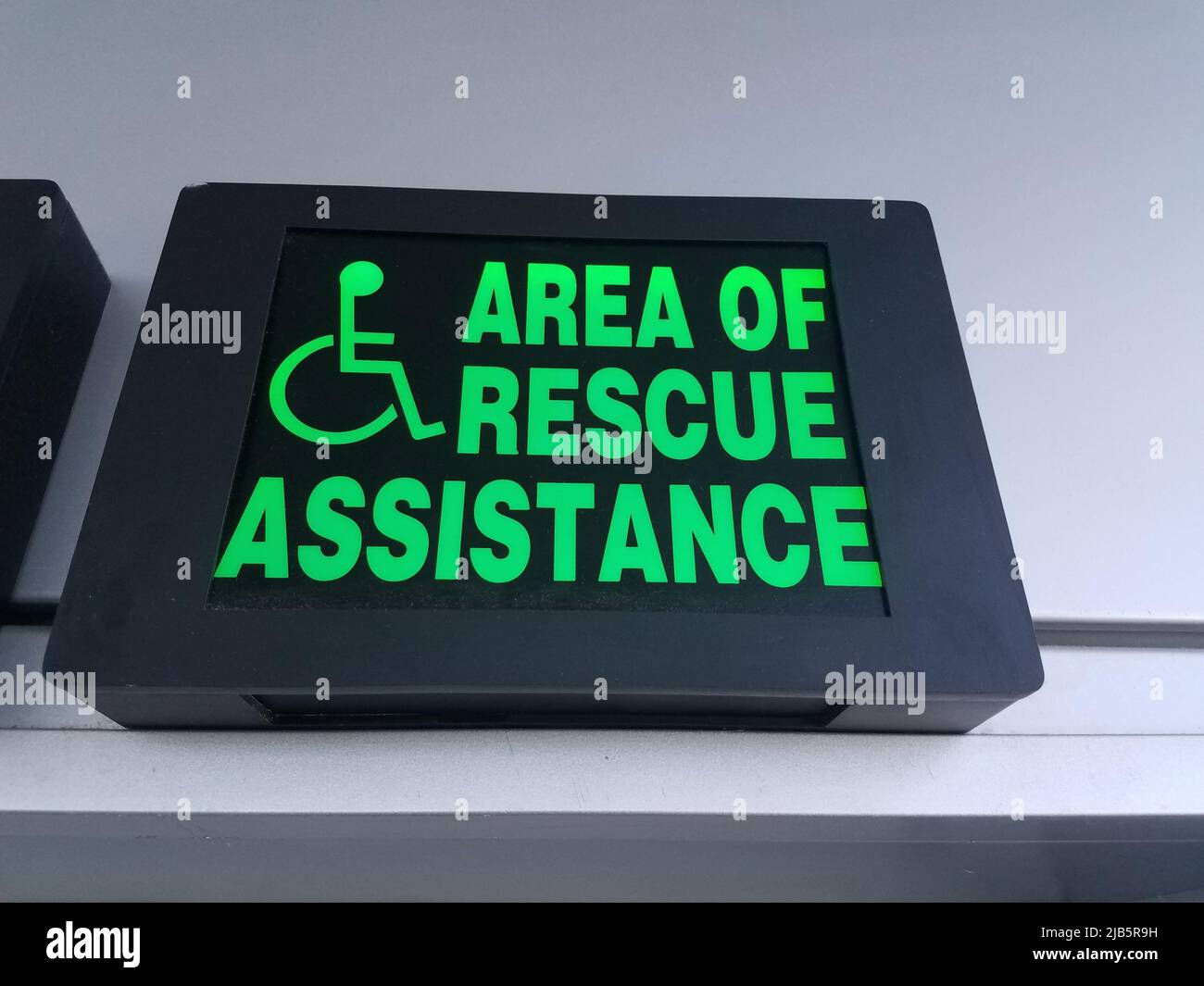 Eine grüne Fläche von Rettungsassistenz Schild mit Rollstuhl. Stockfoto