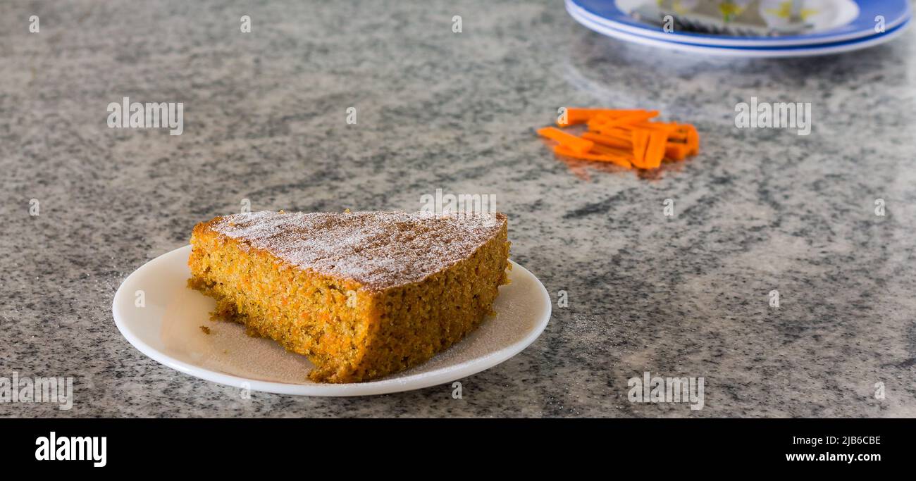 Draufsicht, Nahaufnahme der Scheibe frischer Karottenkuchen mit Puderzucker bestreut oben, isoliert auf weißem Hintergrund. Frisch, feucht, hausgemachter Tee-Kuchen, feucht. Stockfoto