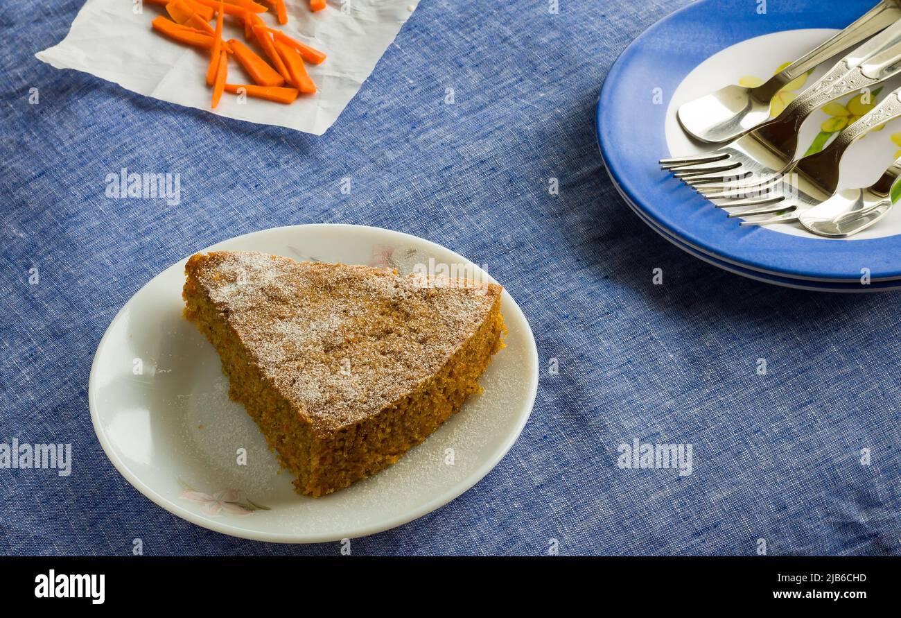Nahaufnahme, Draufsicht der Scheibe frischer Karottenkuchen mit Puderzucker bestreut oben platziert, auf dunkelblauem Hintergrund. Gesunder, feuchter Weihnachtskuchen. Stockfoto