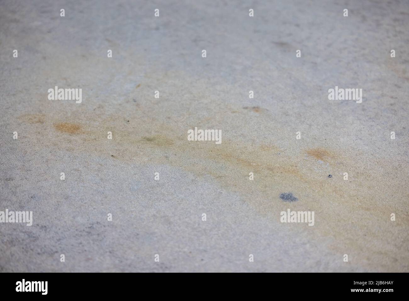 Schmutziger Rost und schmutzige Flecken auf einer Betoneinfahrt oder einem Bürgersteig, die druckgewaschen werden müssen Stockfoto