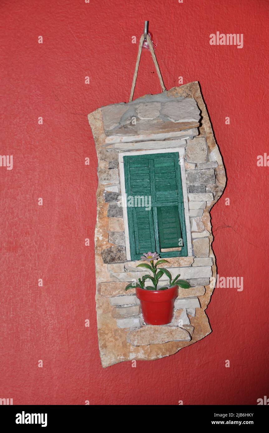 Dekoration Holzjalousien auf rosafarbenem Gebäude. Tageslichtblick auf die pinkfarbene Fassade des Hauses mit passenden Blumen Stockfoto