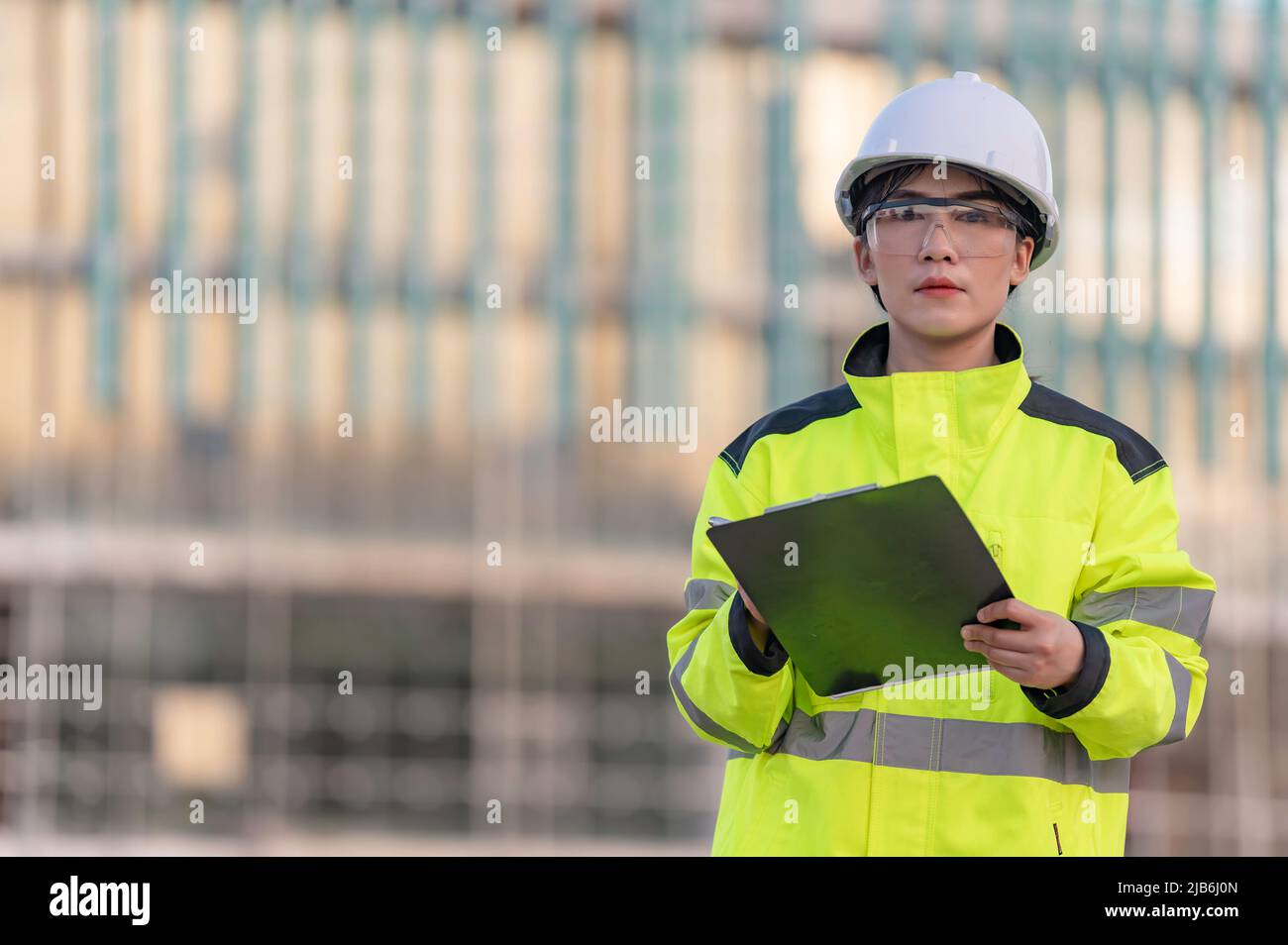 Asiatischer Ingenieur, der vor Ort bei einem großen Bauprojekt arbeitet, Thailänder, Überstunden auf der Baustelle Stockfoto