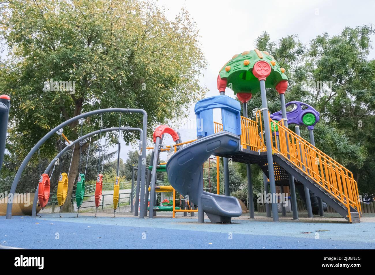 Leerer Kinderpark im Stadtzentrum mit Baumhintergrund. Stockfoto